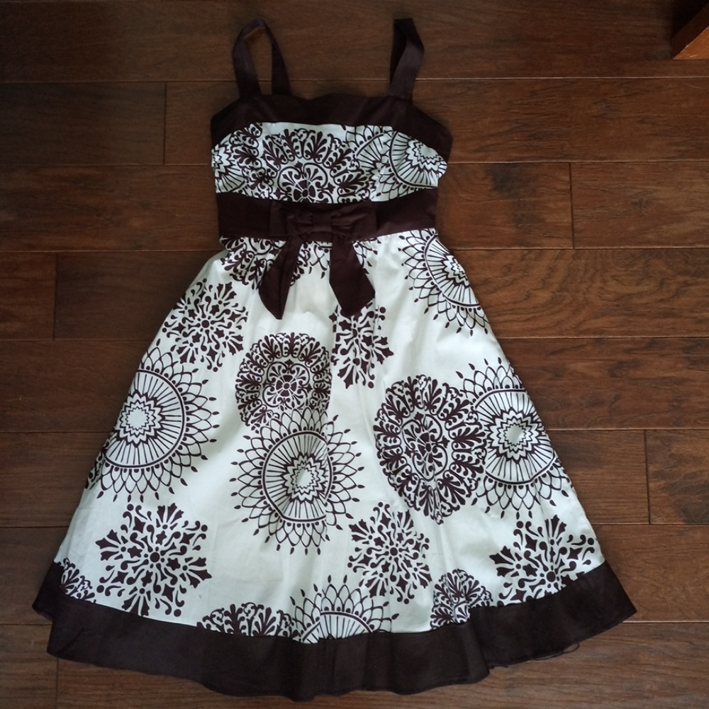 Brown and white patterned dress with bow.